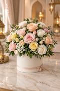 Mixed peach pink yellow and ivory roses in a matte ivory round box