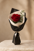 Single deep red rose in black and ivory florist wrap