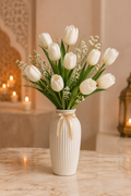 White tulips in a tall ribbed white ceramic vase